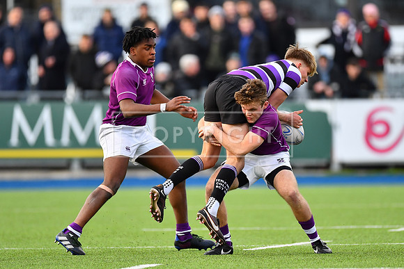Kosi Ugwueru looks on as Callum McDonald makes the hit.