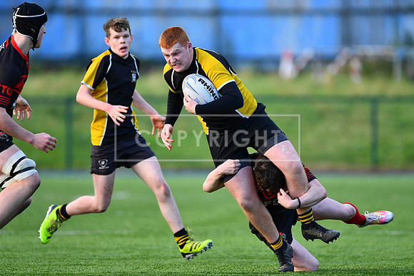 Eoin Carroll of Patricians powers through a tackle.