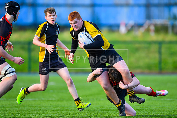 Eoin Carroll of Patricians powers through a tackle.